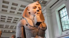 A large Egyptian bust of a pharaoh in a museum