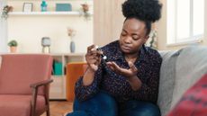 Woman checks her blood sugar levels with a glucometer.