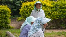 Three elderly women play a game together outside