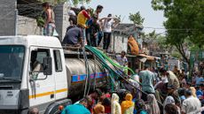 Residents of Snjay Camp in New Delhi fill plastic containers with water from a tanker in June 2026. Severe heatwaves mean that some areas of India's capital experience water shortages in the summer.