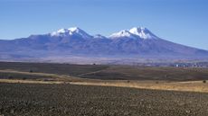 A view of snow-capped mountains over a flat landscape