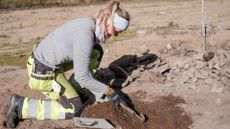 A woman excavates a grave site